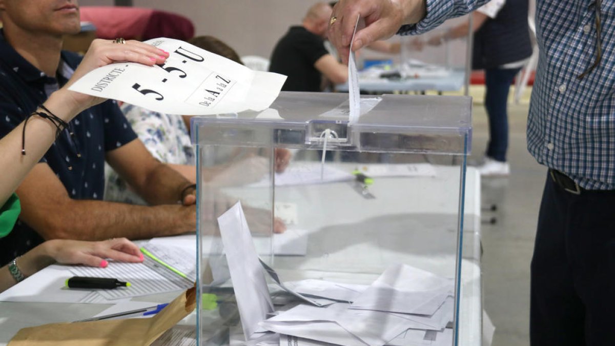 Una persona introdueix el seu vot en una urna del col·legi Fedac de Lleida.