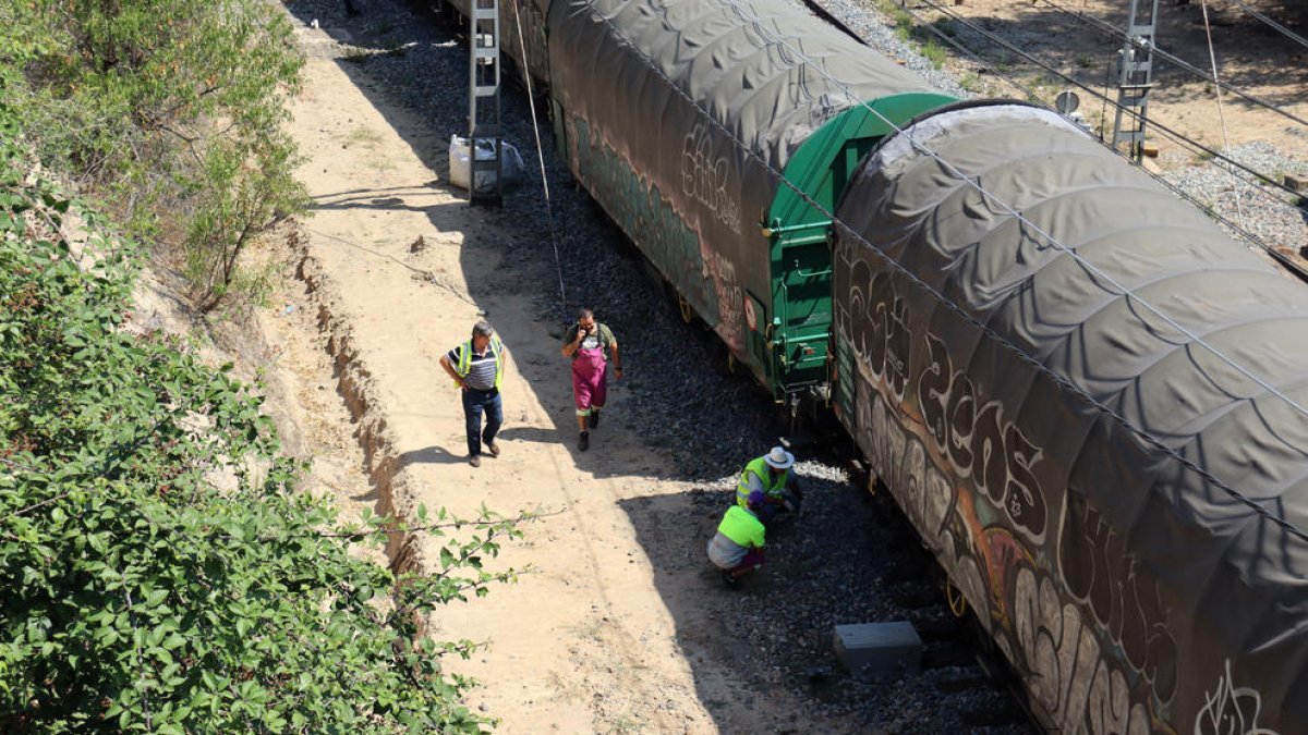 Operaris d'Adif treballant en el tren de mercaderies que ha descarrilat a l'estació Marçà-Falset.