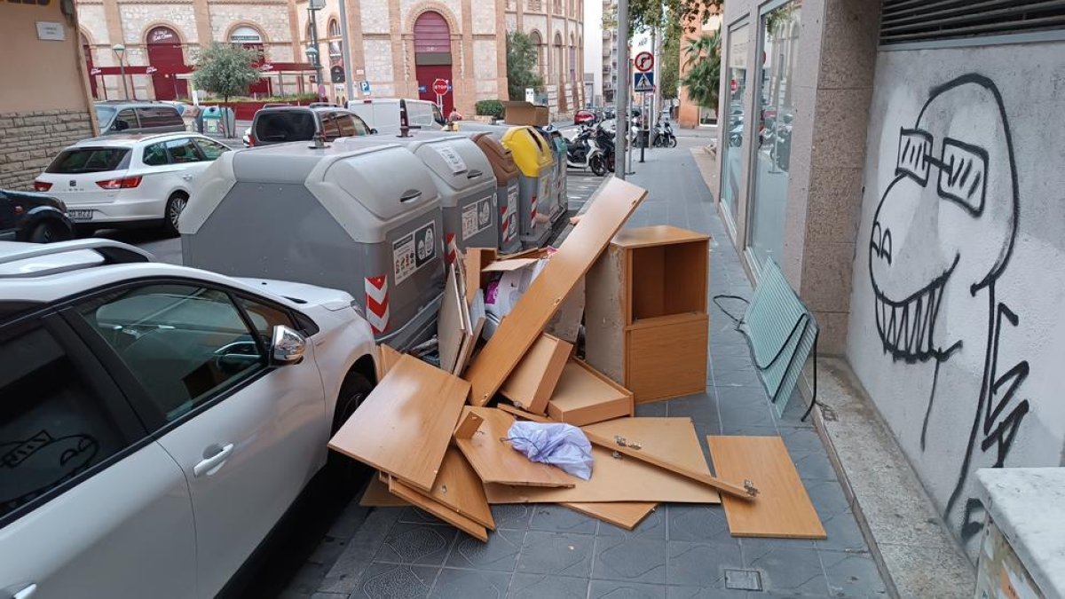 Desechos y muebles que ocupan todo el ancho de la acera en la calle Jaume I de Tarragona.