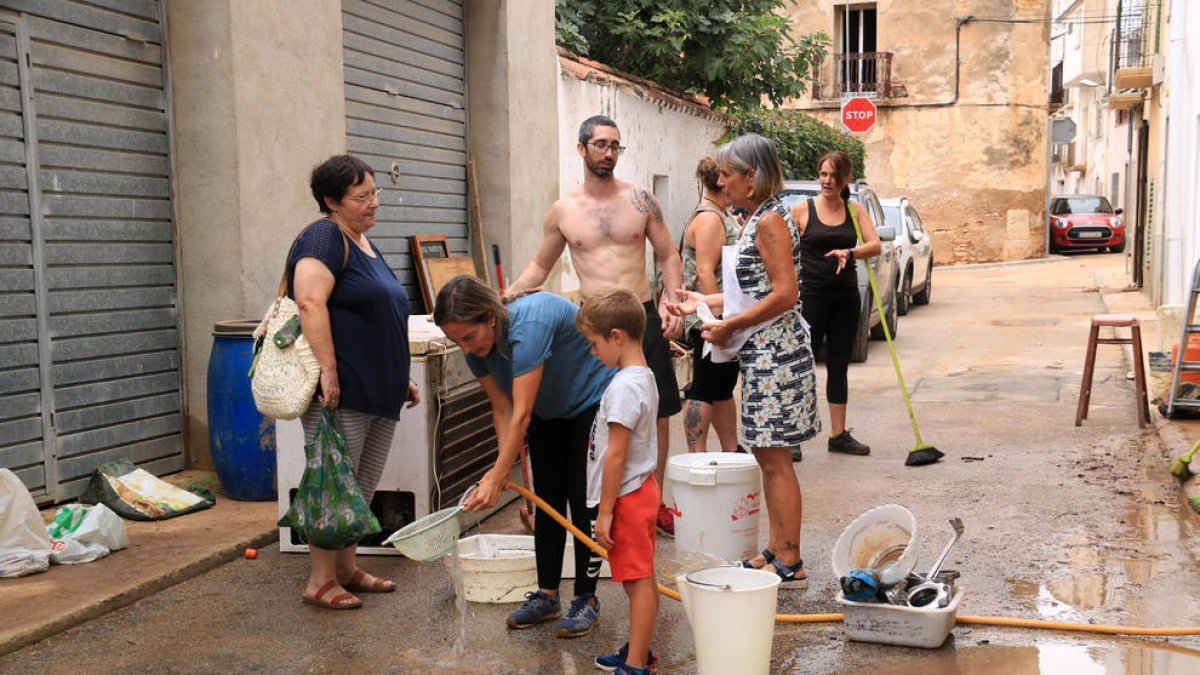 Veïns de Santa Bàrbara l'endemà dels aiguats netejant els baixos inundats pels forts aiguats.