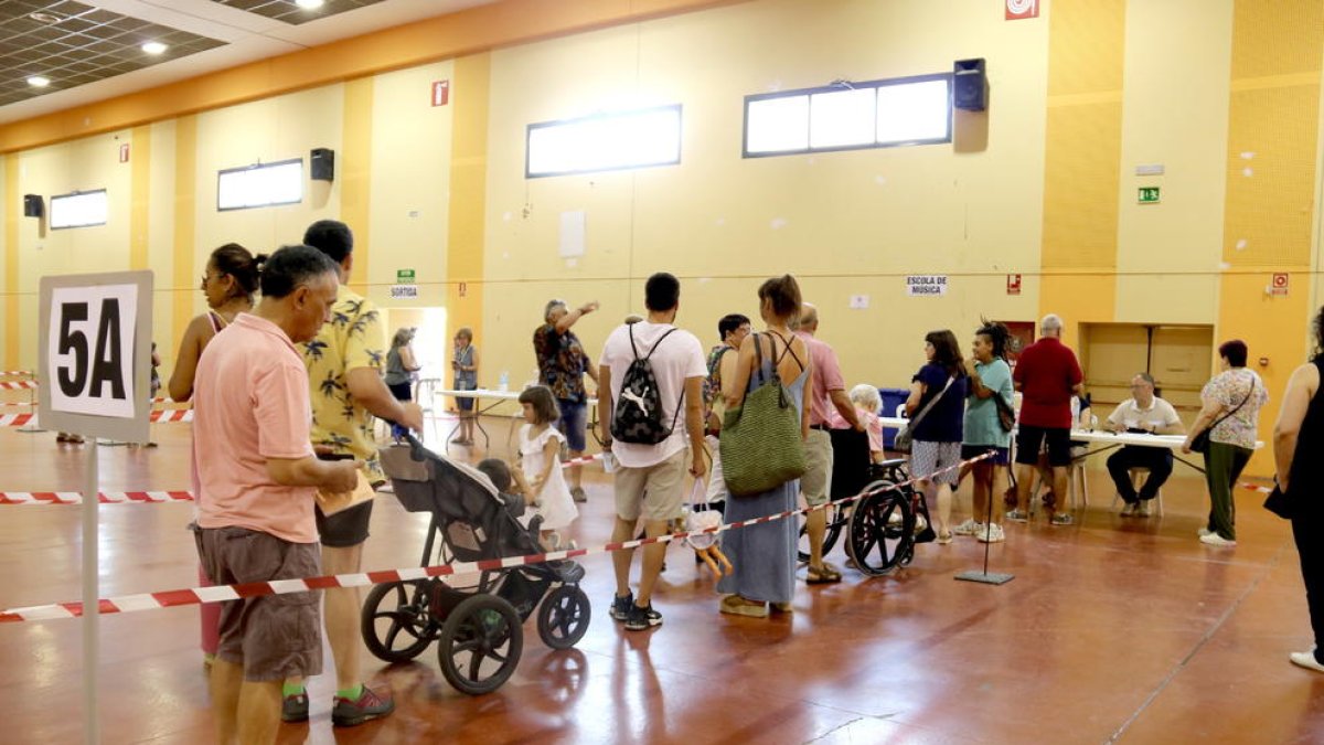 Votantes haciendo cola para depositar sus votos en las urnas.