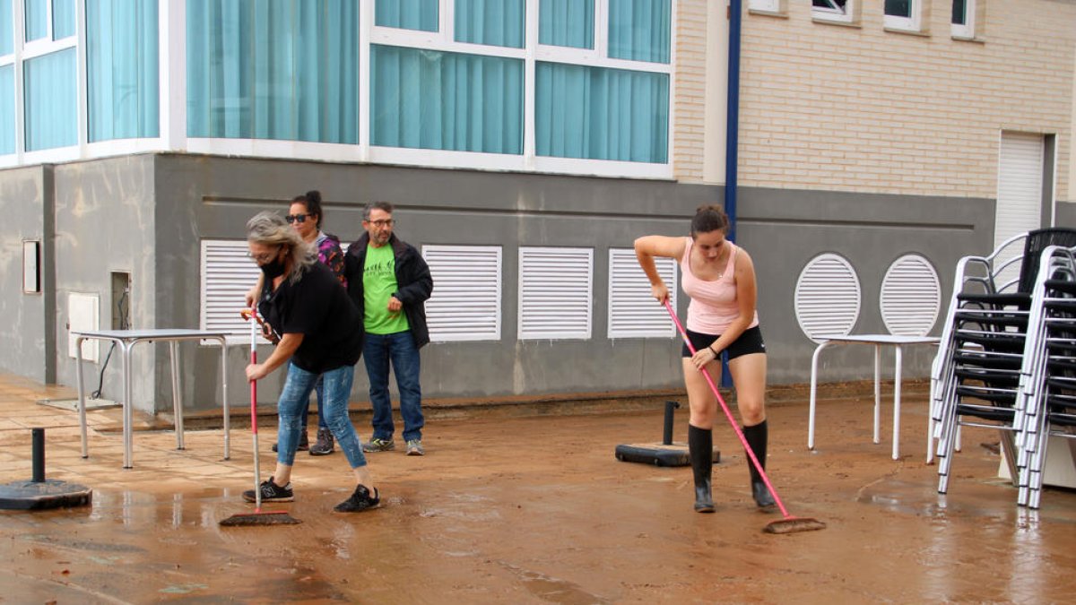 Vecinos de Alcanar retirando el agua acumulada.