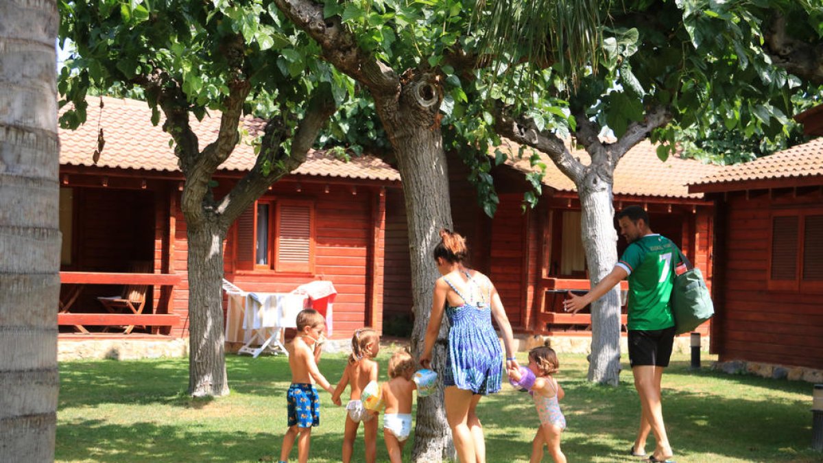 Una familia regresa a su bungalow en el Camping La Llosa de Cambrils.