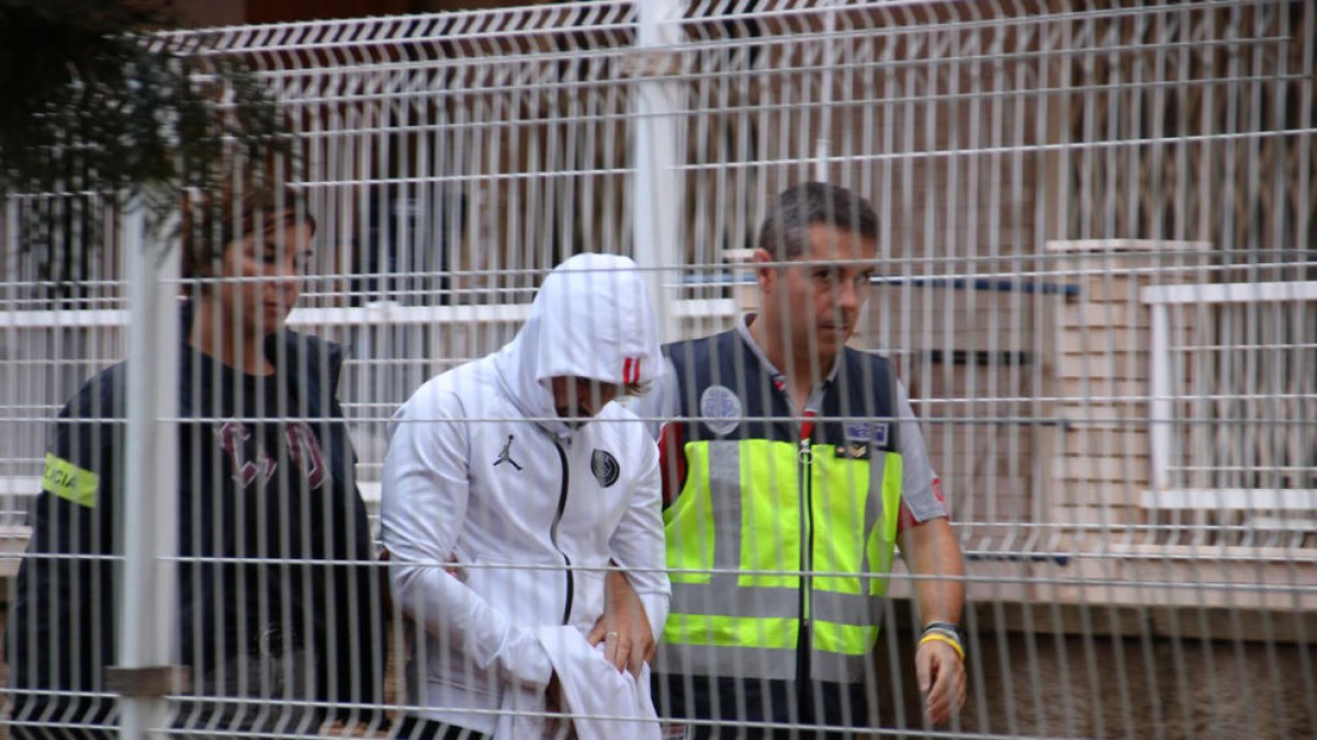 Un detenido en Salou custodiado por agentes de los Mossos d'Esquadra y de la Policía Nacional.