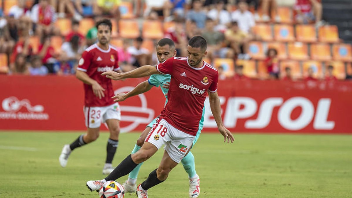 Borja Martínez protegeix la pilota davant un jugador del Barça Atlètic.