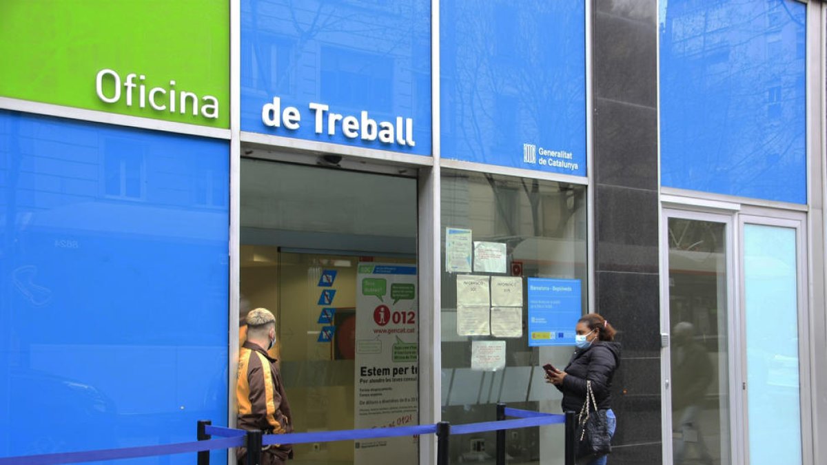 Una dona esperant el seu torn per entrar a l'Oficina de Treball.