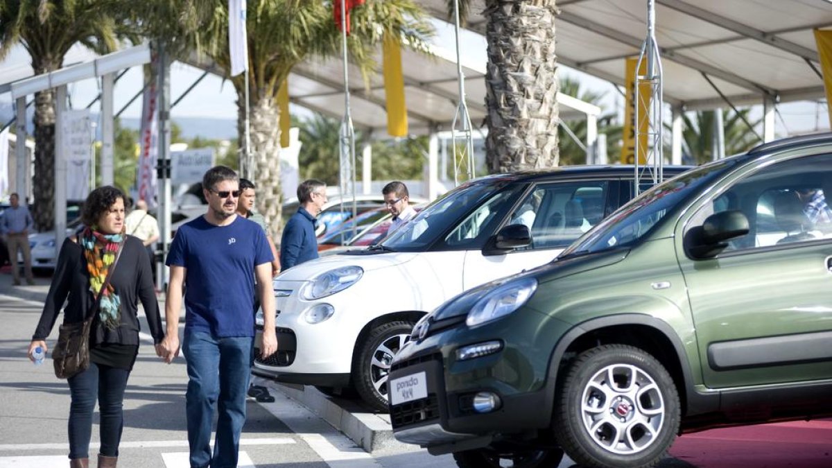 Imatge d'una parella de visitants mirant un vehicle en exposició durant una edició pasada de la fira ExproReus.