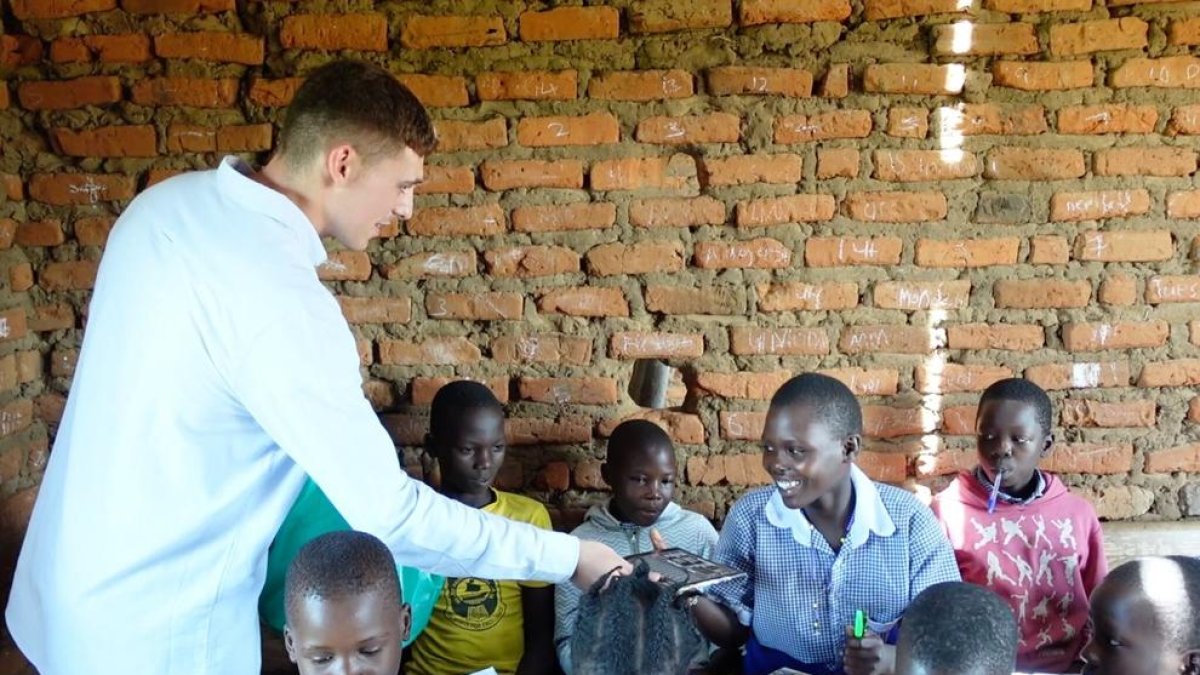 Marc Jardí, fent entrega d'unes llibretes a estudiants d'un centre educatiu d'Uganda.