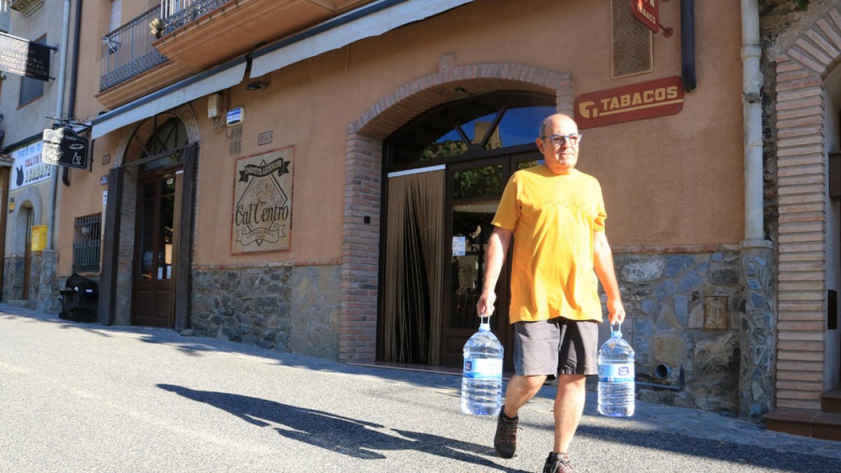 Joan, vecino de Vilella Baixa, carga dos garrafas para evitar el uso de boca del agua del grifo.