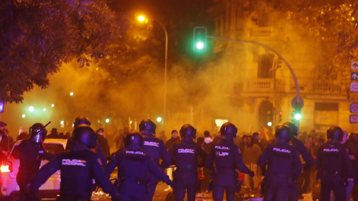 Agentes de la Policía Nacional intervienen durante la concentración de este lunes frente a la sede del PSOE en la calle Ferraz, en Madrid