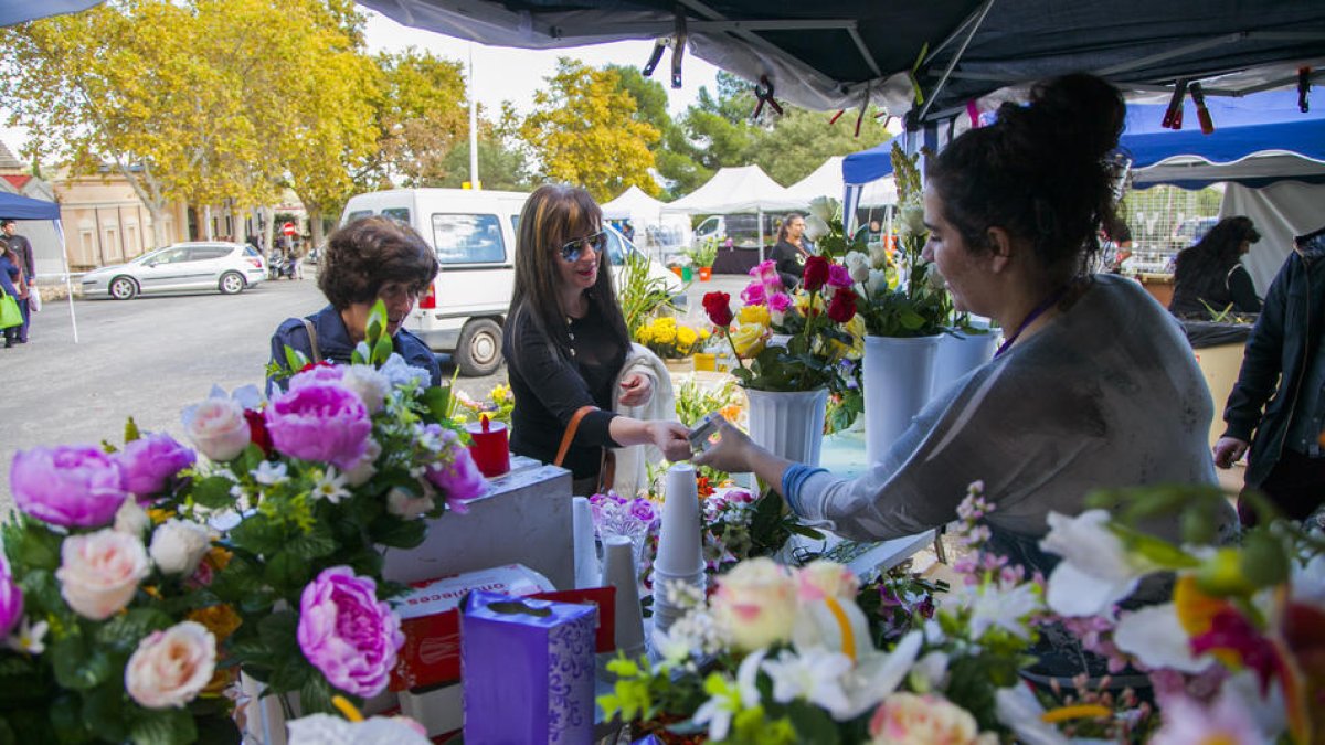 Imagen de archivo de clientes comprando flores en una parada en el cementerio de Tarragona.