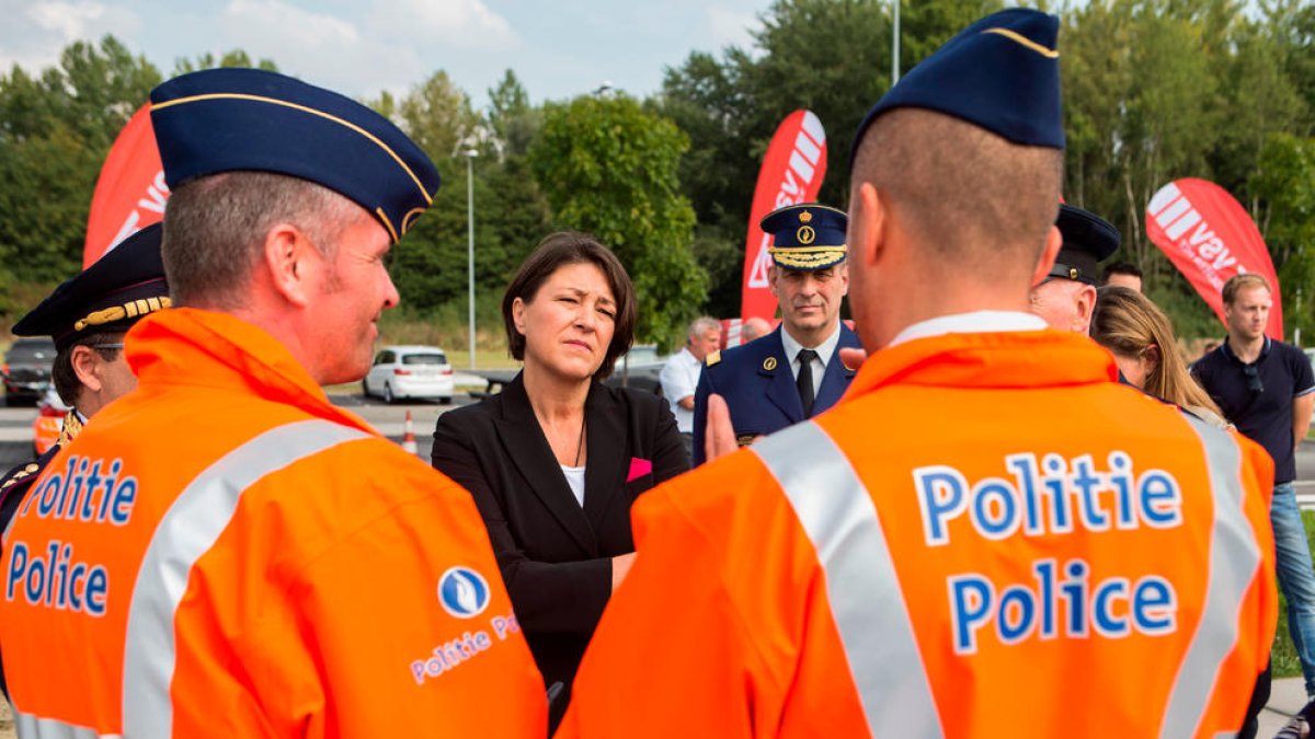 Imatge d'arxiu de dos membres de la policia federal belga conversant amb l'excomissària de Transport, Violeta Bulc