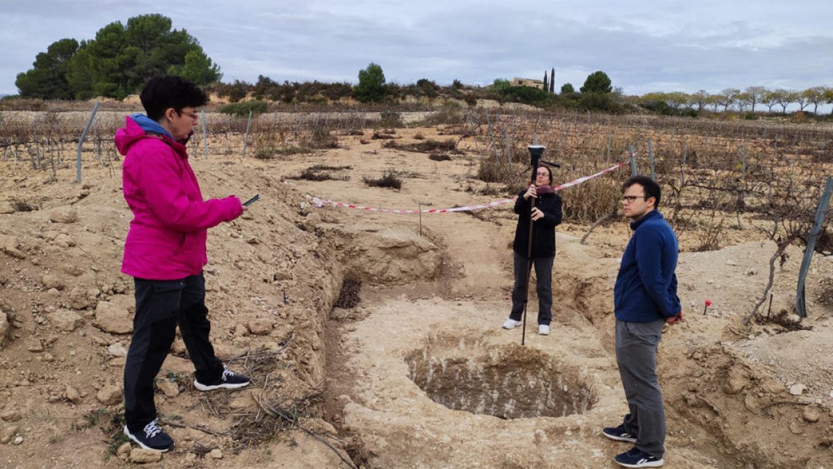 Trabajos de topografía en el yacimiento, con el Mas Cap de Ferro al fondo.