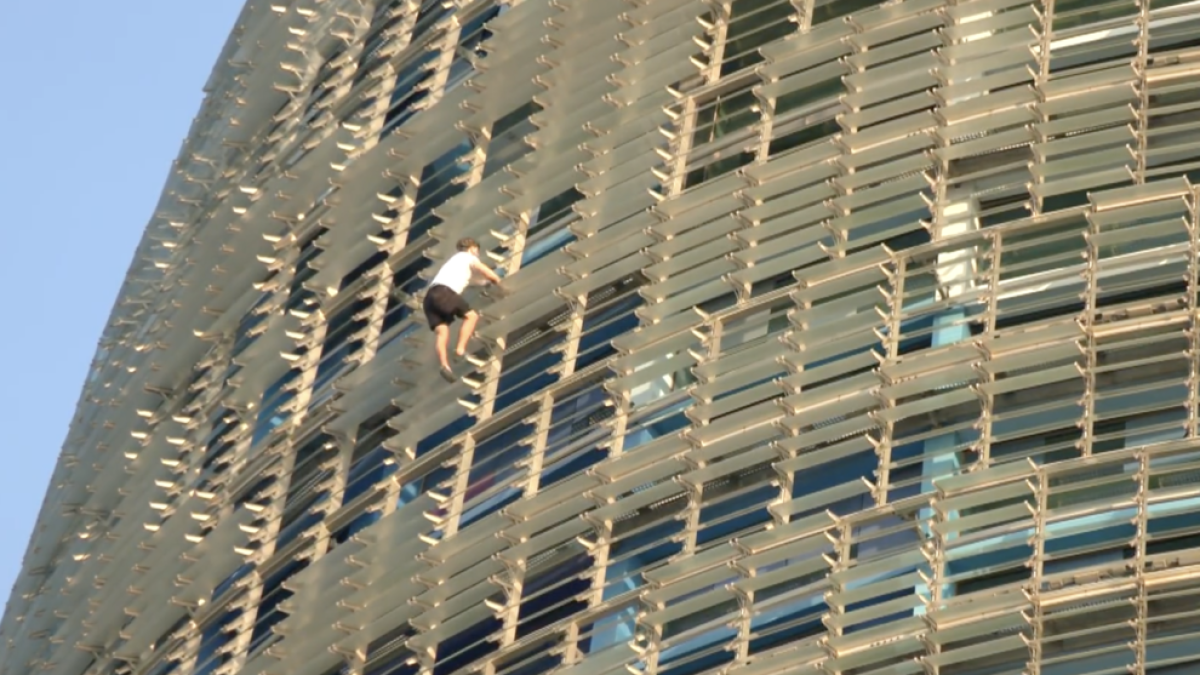 Imatge d'un dels homes escalant sense protecció la Torre Glòries de Barcelona.