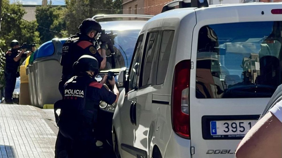 Agents dels Mossos apunten contra un domicili de Terrassa on s'ha atrinxerat un home després de disparar-ne un altre.