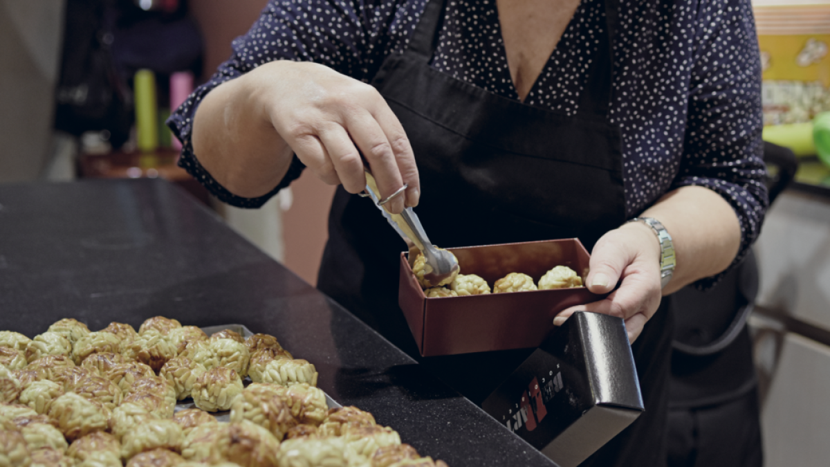 Imatge d'arxiu d'una pastissera preparant una safata de panellets de pinyons, un dels més demandats any rere any.