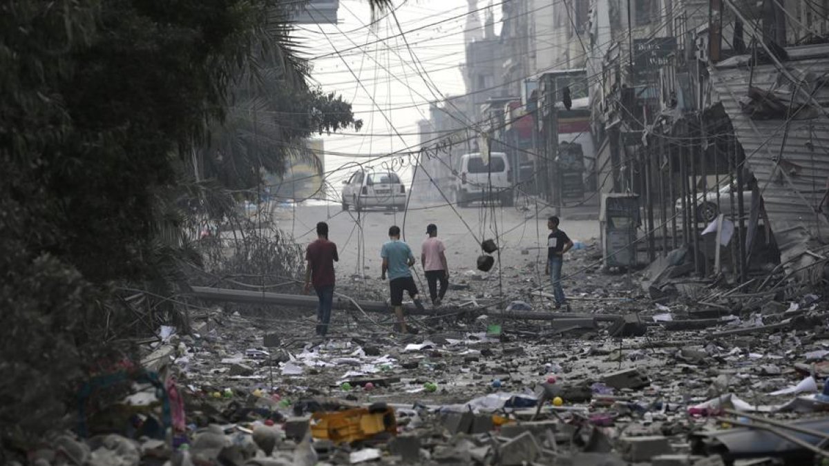 Un grupo de palestinos en una zona arrasada por los ataques israelíes en Gaza.