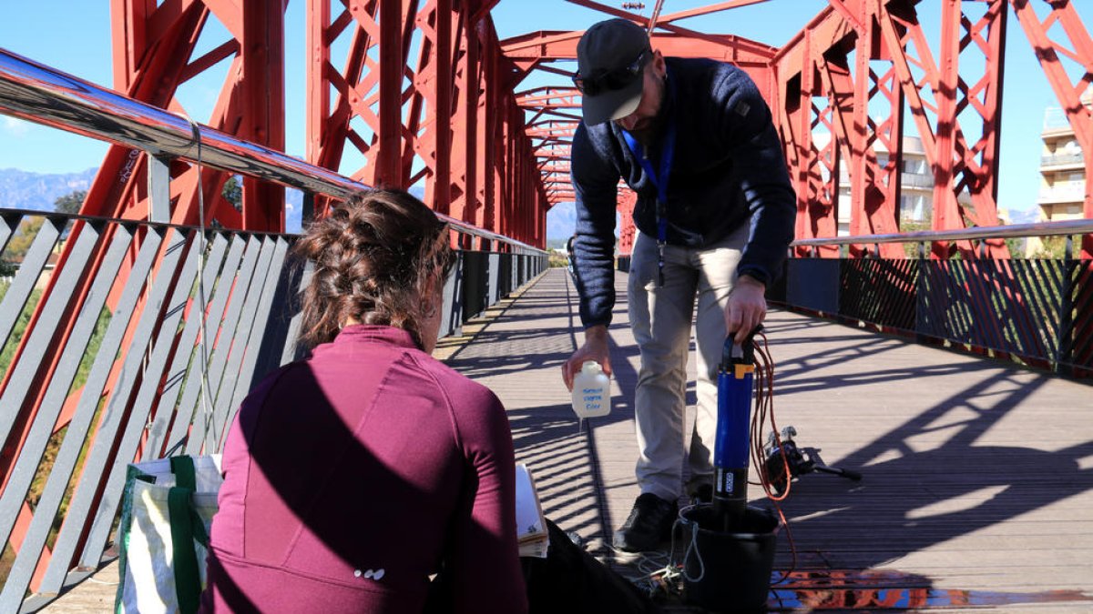 Dos investigadors de la Universitat de Lleida prenen mostres de l'aigua de l'Ebre al pont roig de Tortosa.