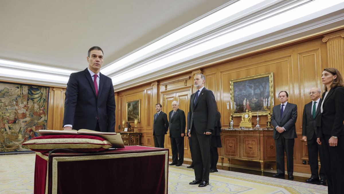 Pedro Sánchez promete su cargo de presidente del Gobierno ante el rey Felipe VI y un ejemplar de la Constitución.