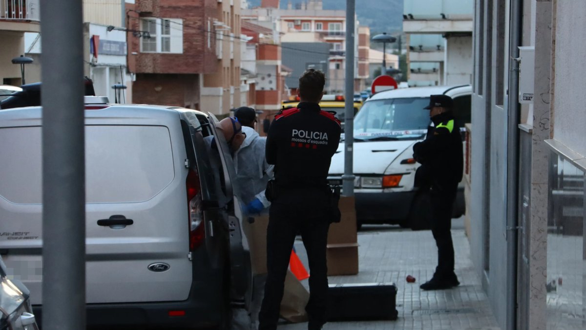 Imatge de l'exterior de l'edifici del carrer Xile d'Amposta on s'ha trobat el cos, amb agents a la porta.