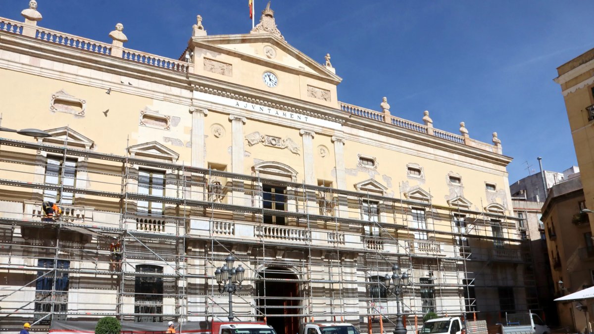 Imatge de la façana de l'Ajuntament de Tarragona, amb els operaris col·locant la bastida per a les obres de rehabilitació.