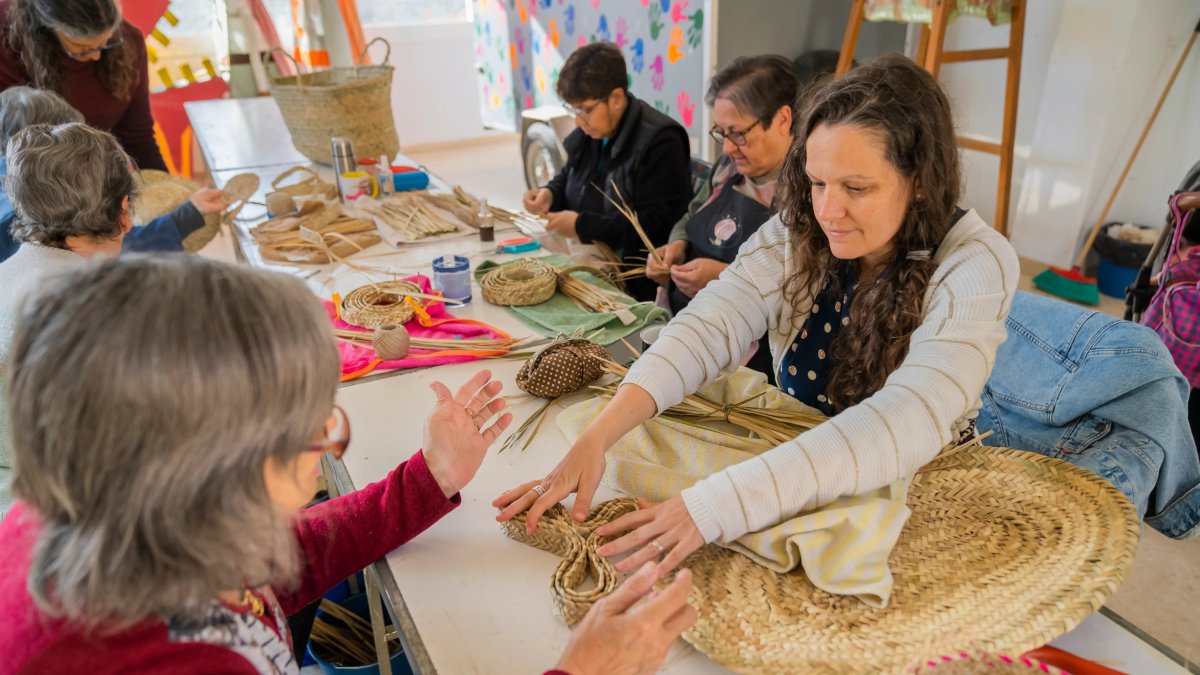 Assistents del taller obert treballant en les seves cistelles.