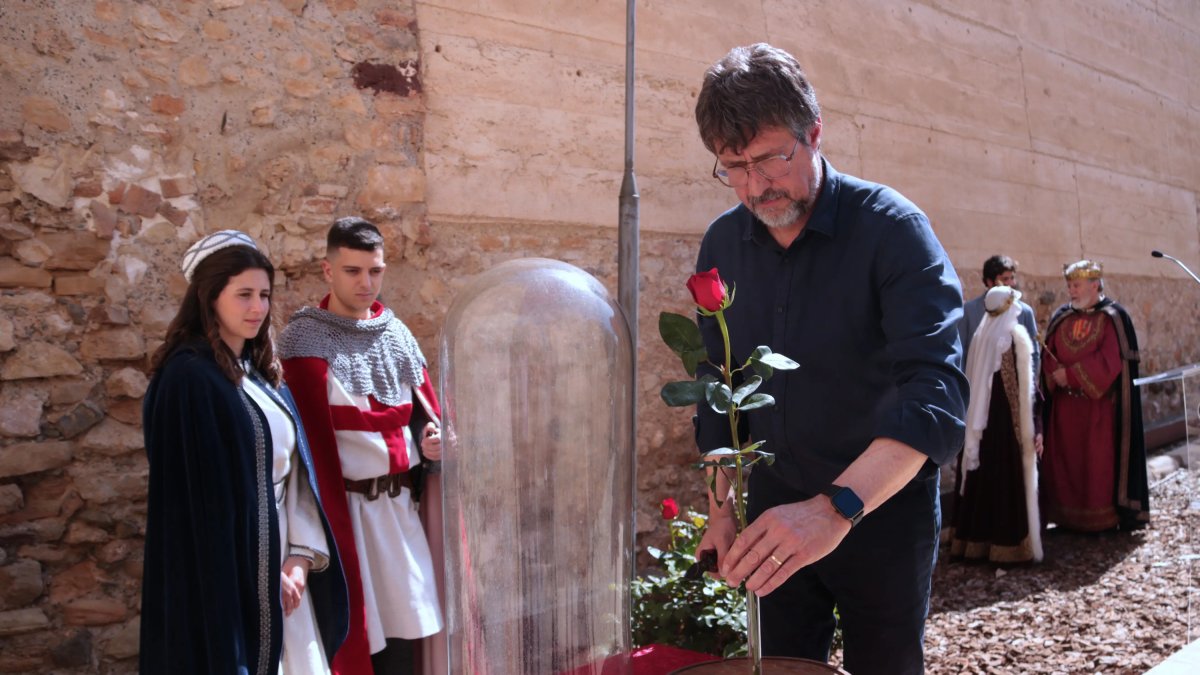 El president de l'Associació Medieval de la Llegenda de Sant Jordi, Maties Martí, col·loca la primera rosa de Catalunya en un recipient de vidre.