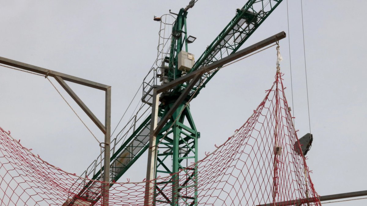 Imatge d'una grua en un bloc de pisos en construcció.