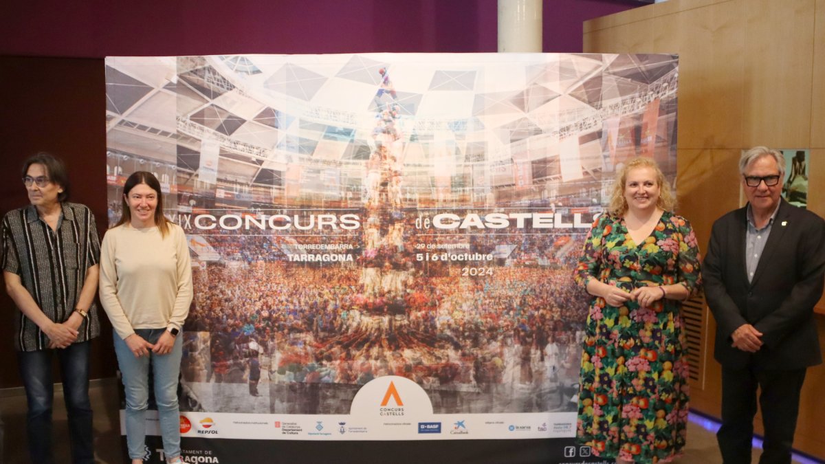 Impulsors del Concurs de Castells de Tarragona, davant la lona amb el cartell del certamen.