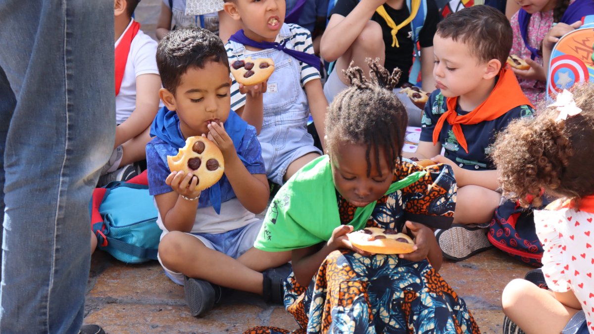 Diversos nens menjant coca amb cireres.