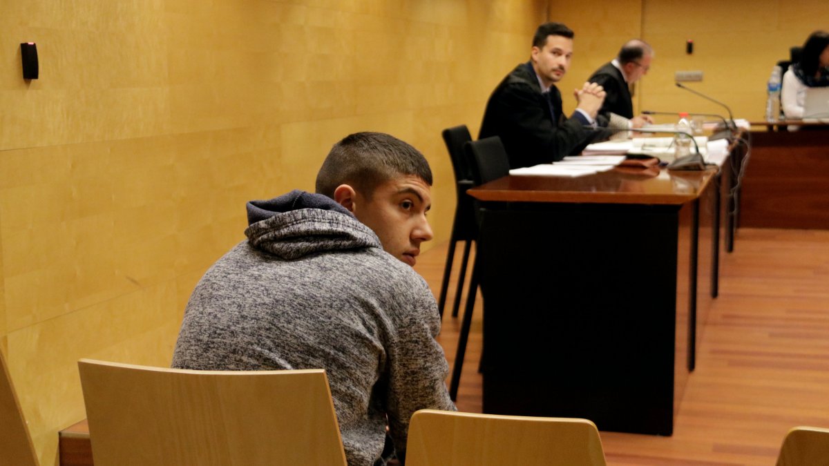 D'esquenes, l'acusat de matar la mare a ganivetades a Ripoll. Foto del judici a l'Audiència de Girona.