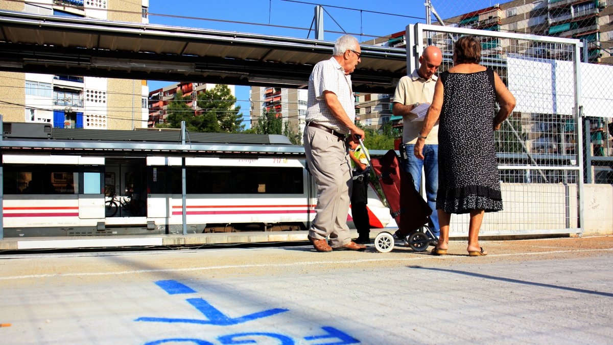 Un home indica uns usuaris d'edat avançada com han d'anar a Barcelona a l'estació de Bellvitge