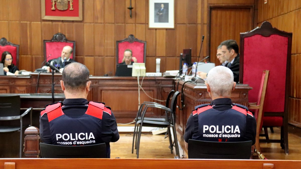 Dos agents dels Mossos d'Esquadra i la cadira de l'acusat d'esquera durant el judici a l'Audiència de Tarragona.