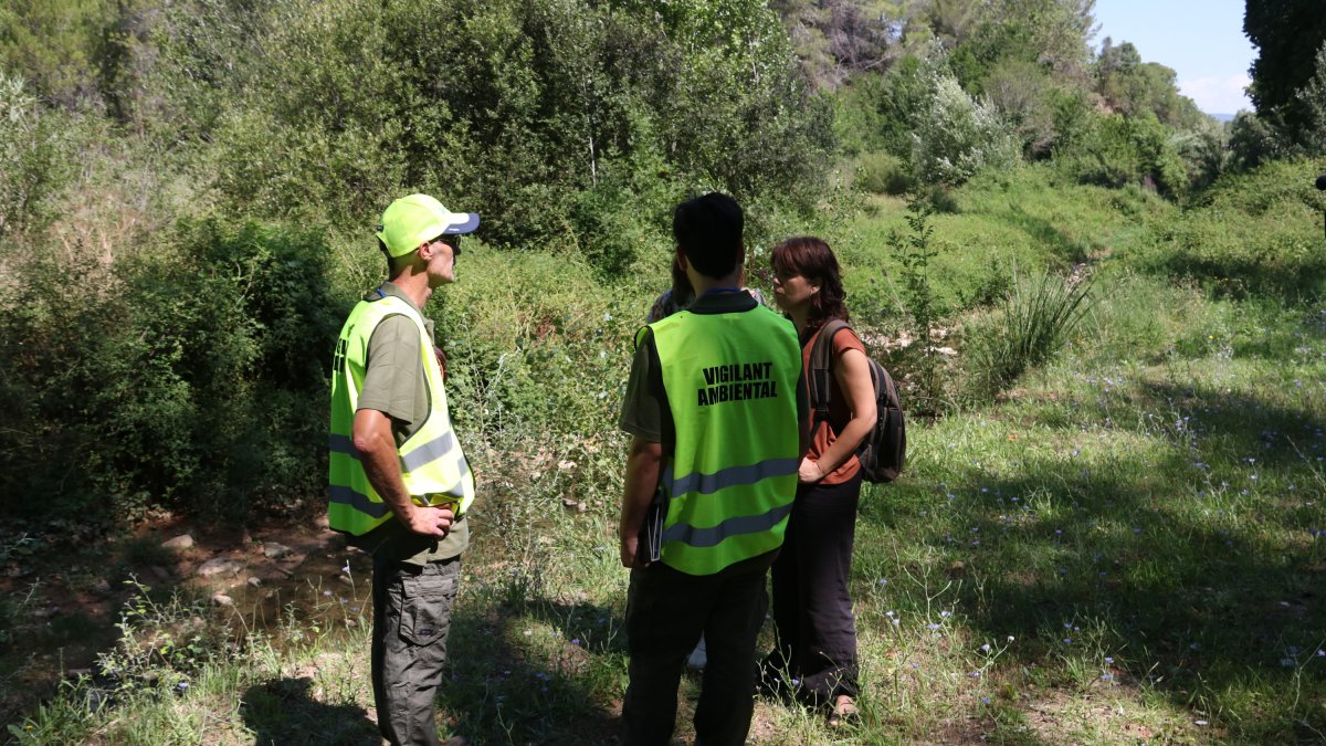 Un parell d'informadors ambientals conversen amb visitants de l'Albereda de Santes Creus.