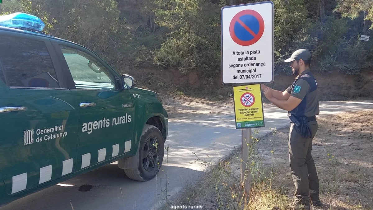 Un Agent Rural col·loca un cartell de prohibició de circulació per perill d'incendi forestal