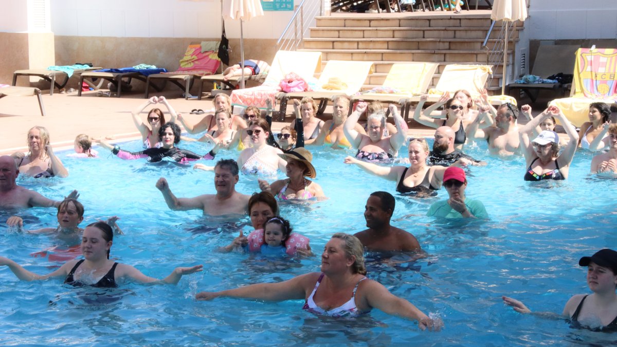 Un grup de persones fan una classe dirigida a una de les piscines de l'hotel Golden Port de Salou.
