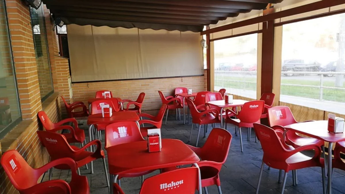 Imagen de archivo de la terraza de un bar con sillas y mesas Mahou.