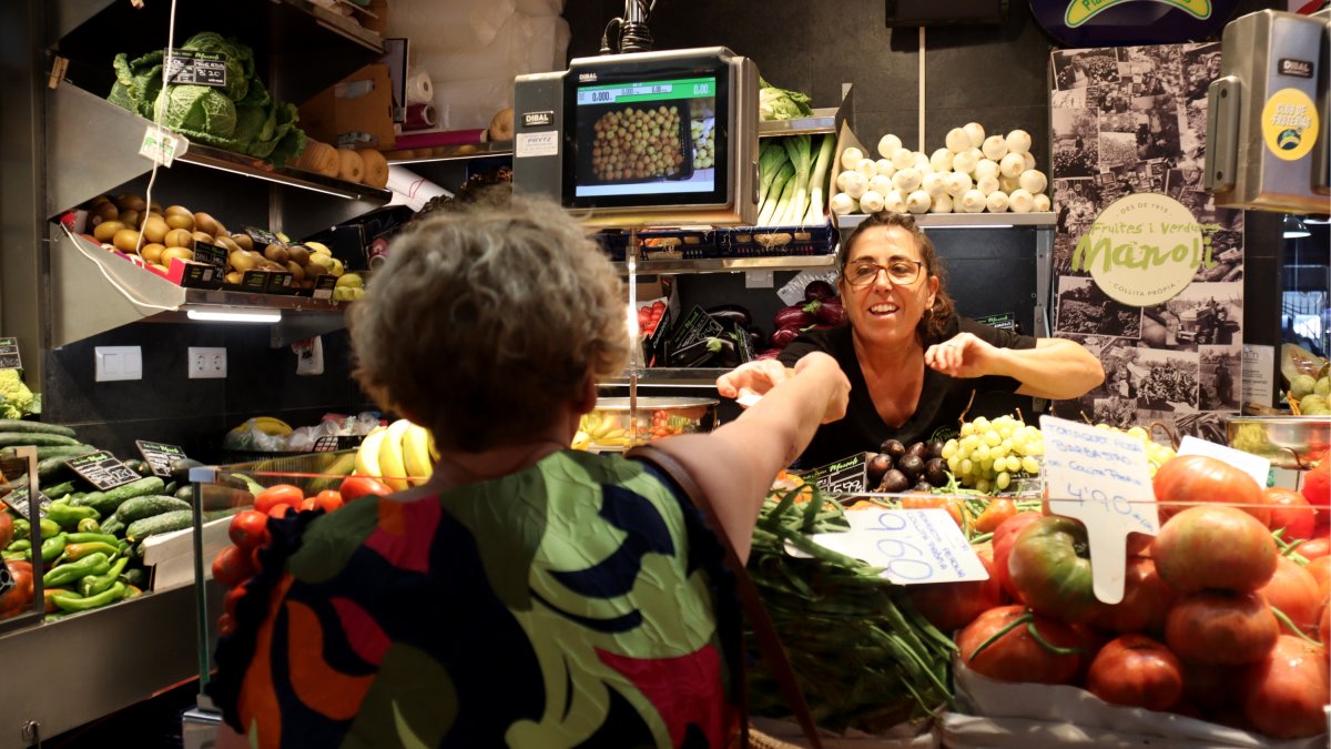 Una treballadora d'un dels comerços del Mercat Central de Tarragona atenent una clienta