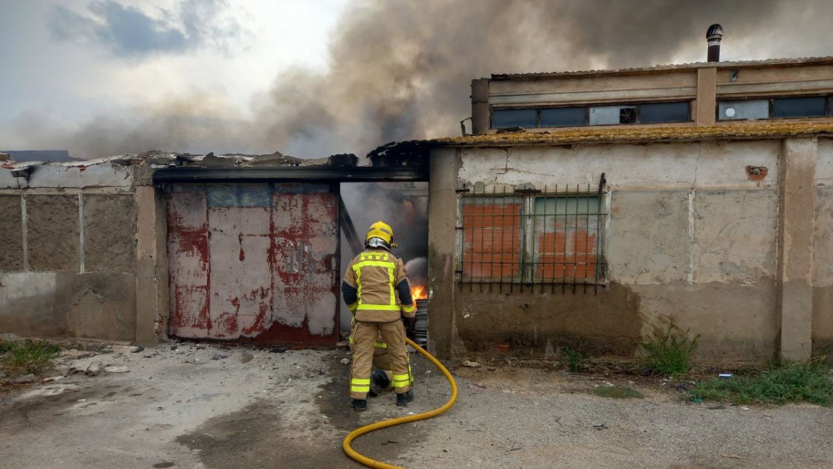 Imatge d'un bomber treballant en l'incendi d'una nau a Reus