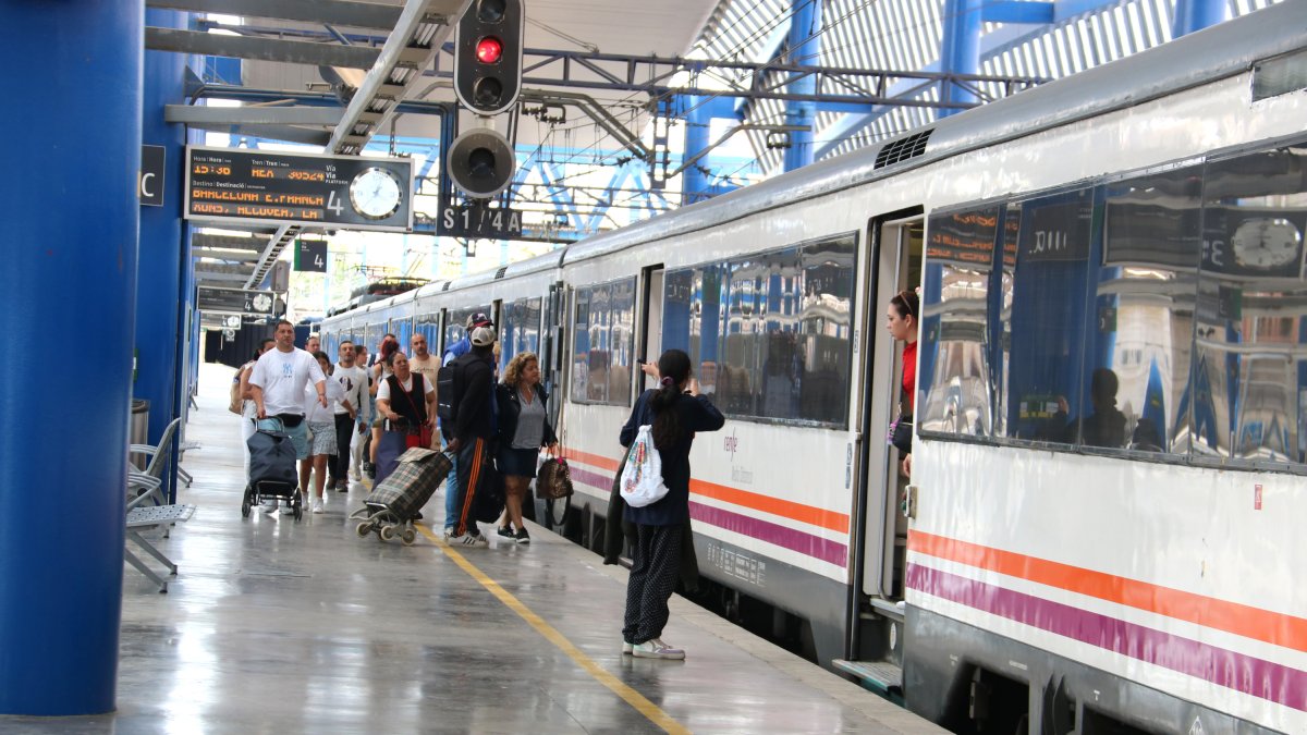 Persones pujant al tren de l'R14 des de l'estació Lleida-Pirineus