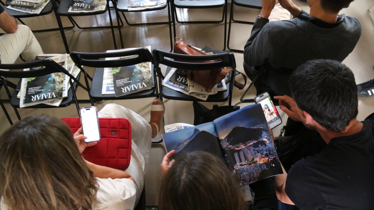 Assistents al Terres Travel Festival fullejant revistes de viatges en paper i digitals en la jornada professional al Museu de Tortosa.