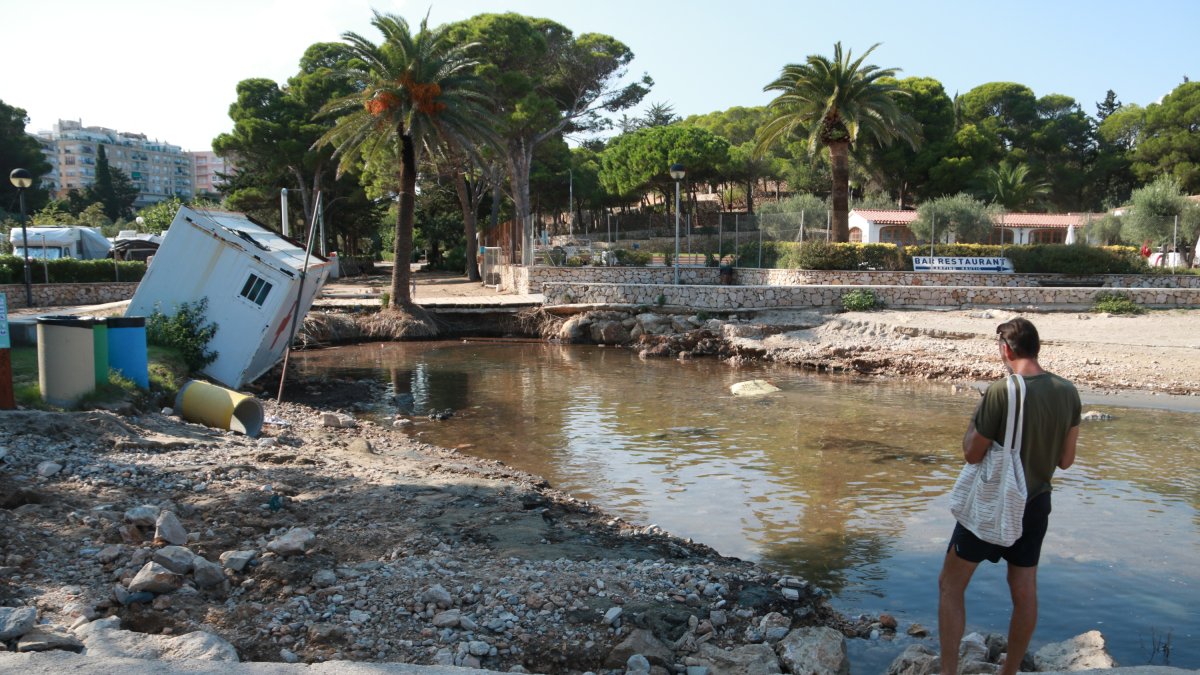 Un home fotografia l'aspecte que ofereix la cala de Pixavaques a l'Ametlla de Mar després dels aiguats de dissabte