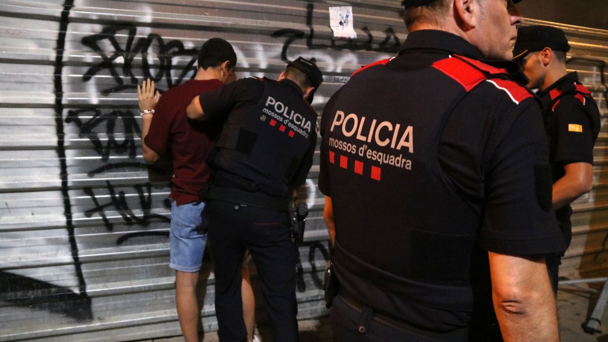 Els agents dels Mossos escorcollen un jove a les festes de Santa Tecla.