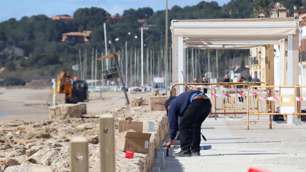 Una persona treballant a les obres de reparació del passeig marítim d'Altafulla.