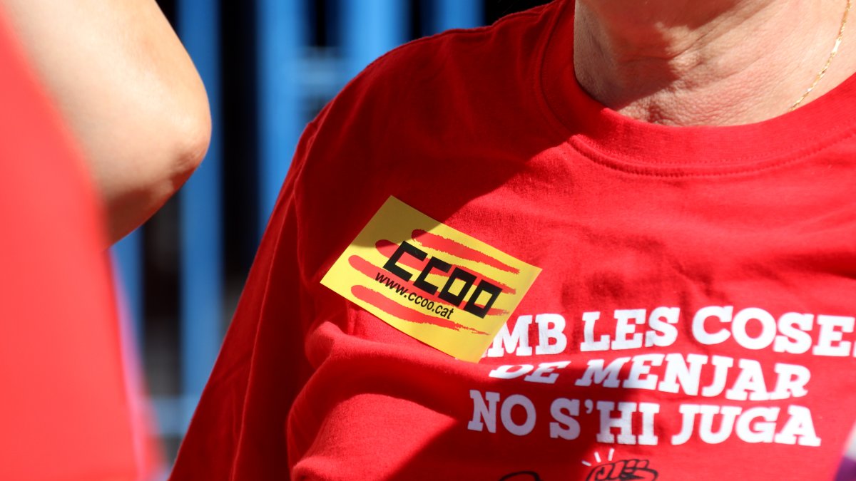 Una de les manifestants per la reducció de la jornada laboral a Tarragona amb una pegatina i samarreta de CCOO.