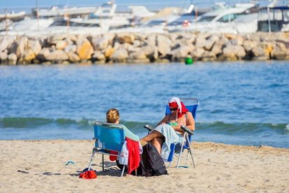 Imatge de dues persones a la platja.
