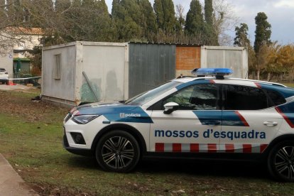 La casa custodiada amb un vehicle policial.