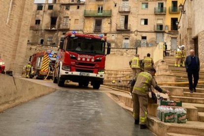 Bomberos trabajando en el incendio de un inmueble en la calle Capellans de Tortosa.