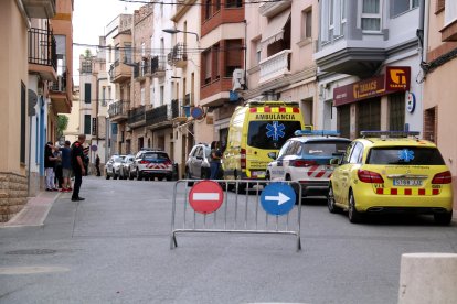 Calle cortada en el Perelló con policías y vecinos delante de la casa donde un hombre ha muerto desangrado.