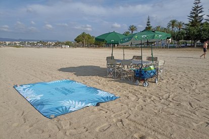 Imatge de la tovallola, cadires i para-sols que reservaven l'espai a la platja de Cambrils.